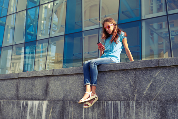 Kaupungin elämäntapa tyylikäs nuoriso älypuhelimella istuu vastaan
  - Valokuva, kuva