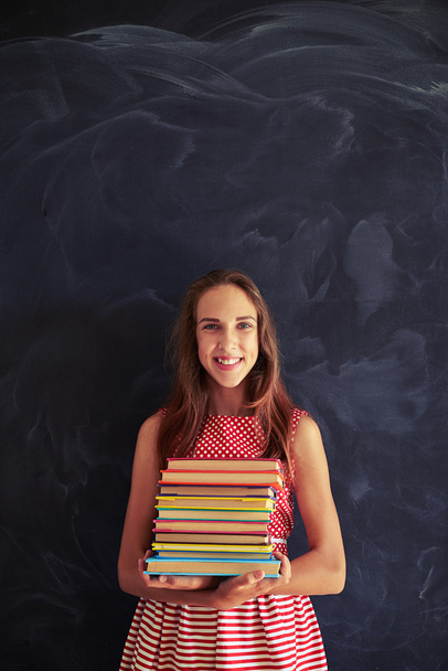 Close-up of beautiful girl standing with books in her hands agai - Fotoğraf, Görsel