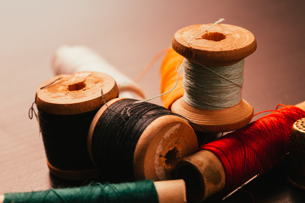 vintage reel of thread and thimble on a wooden background - Фото, изображение