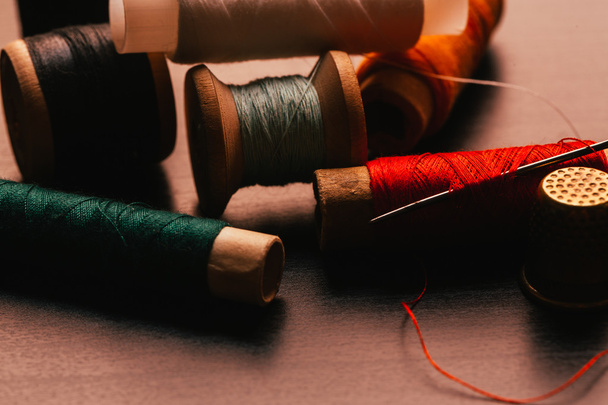 vintage reel of thread and thimble on a wooden background - 写真・画像