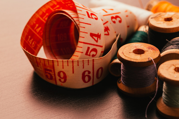 lot Vintage spools of thread thimble and measuring tape on a wooden background - Фото, зображення