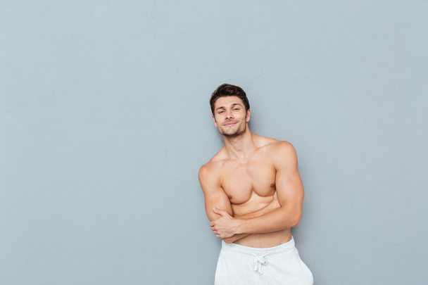 Smiling confident shirtless young man standing with arms crossed - Photo, image
