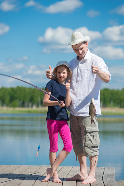 Dad and daughter caught fish from the pier on the lake - Fotografie, Obrázek