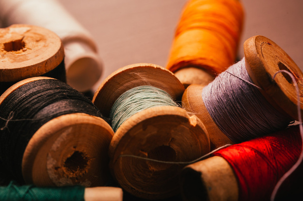 vintage reel of thread and thimble on a wooden background - 写真・画像