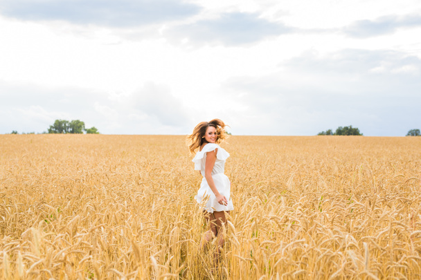 ευτυχισμένη γυναίκα άλμα στο χρυσό σιτάρι - Φωτογραφία, εικόνα