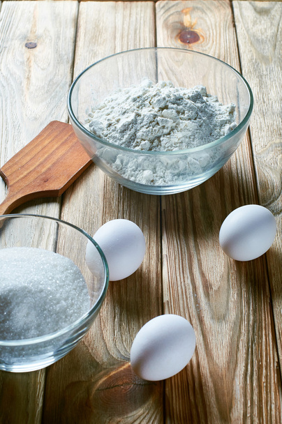 Mąkę, cukier, jajka i szpatułki drewniane kuchnia na stole od Starego drzewa. - Zdjęcie, obraz