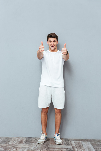 Full length of cheerful man standing and showing thumbs up - Foto, Imagen