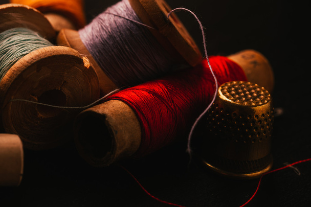 vintage reel of thread and thimble on a wooden background - Fotó, kép