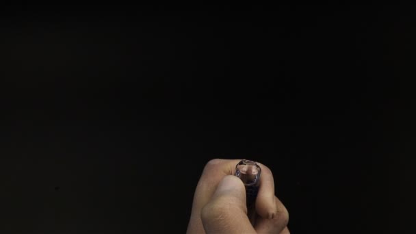 Médico em luvas médicas abre a ampola com medicamento em fundo preto
 - Filmagem, Vídeo