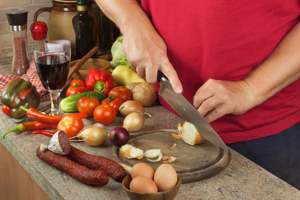 Koch geschnittene Zwiebel an Bord. Gemüse für einen gesunden Salat zubereiten. Zwiebeln und Tomaten schneiden. Frisches Gemüse in der Küche. - Foto, Bild