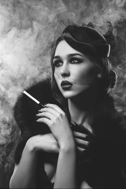Gyönyörű lány füstös szemek és vörös ajkak cigaretta tartó - Fotó, kép