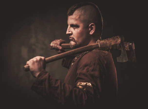 Viking sério com machado em uma roupa de guerreiro tradicional
 - Foto, Imagem