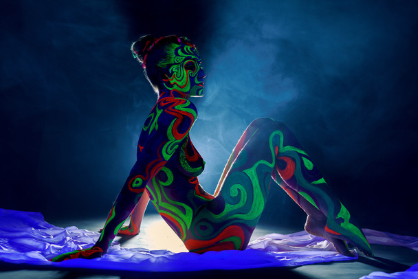 Girl with body art glowing under ultraviolet light - Photo, Image