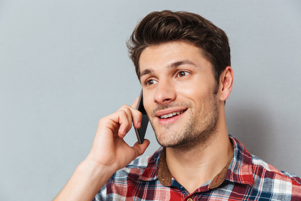 Closeup of happy young man talking on cell phone - Foto, afbeelding