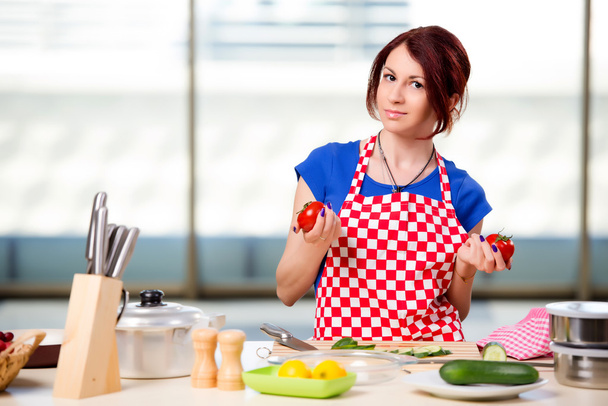 Женщина готовит салат на кухне - Фото, изображение