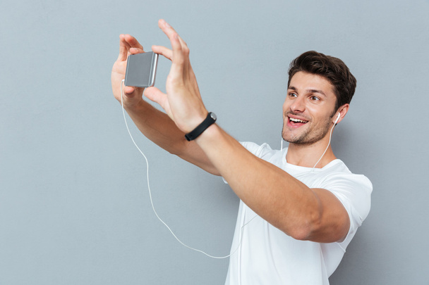 Casual young man making selfie photo on smartphone - Foto, afbeelding