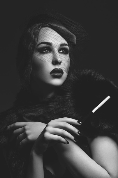 Kaunis tyttö savuinen silmät ja punaiset huulet tilalla savuke
 - Valokuva, kuva