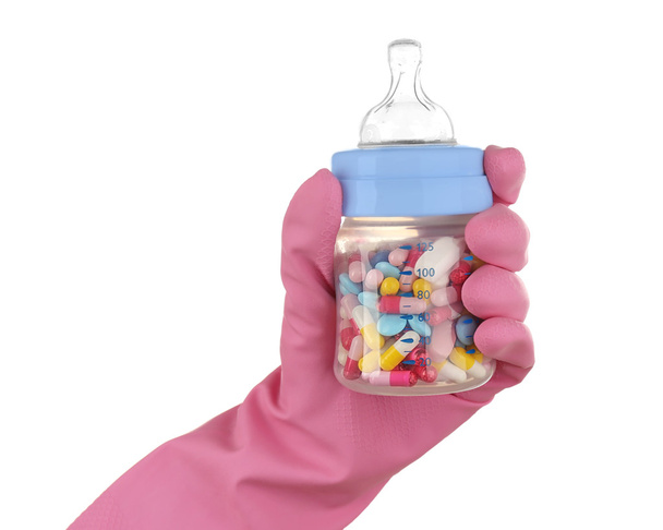 Hand in glove holding feeding bottle  - Foto, Bild