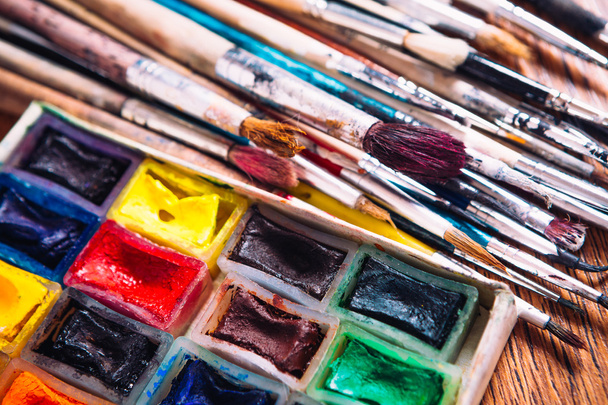 Many brushes and paint for painting on wooden background - Foto, imagen