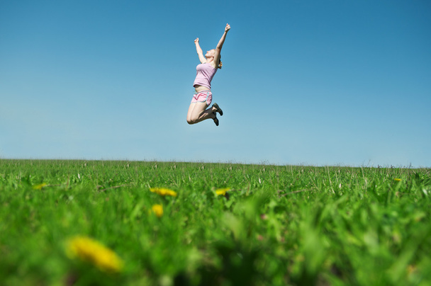 Nuori tyttö hyppää korkealle
 - Valokuva, kuva