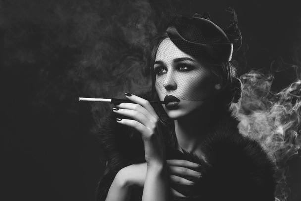 Gyönyörű lány füstös szemek és vörös ajkak cigaretta tartó - Fotó, kép