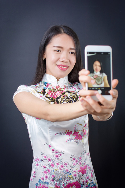 Молодая женщина делает селфи со смартфоном
 - Фото, изображение