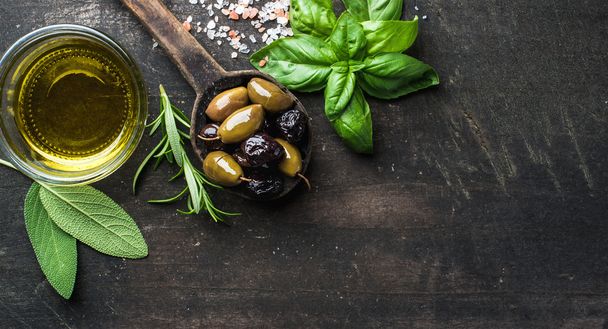 Green and black Mediterranean olives with fresh herbs - Фото, изображение