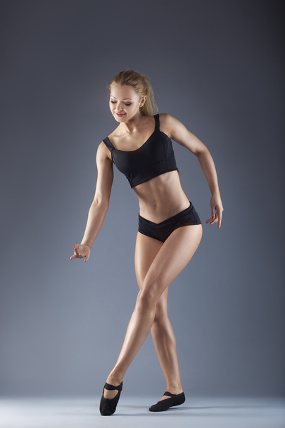 Young beautiful dancer posing on a studio background - Photo, image