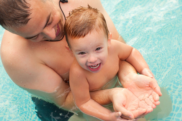 Father and son having fun in the swimming pool on beautiful summer day - Foto, Imagem