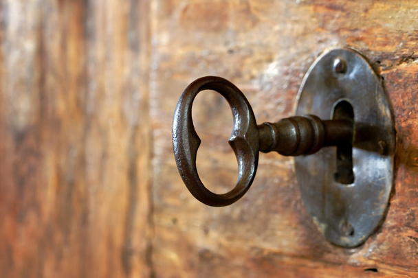 Closeup of an old keyhole with key - Photo, Image