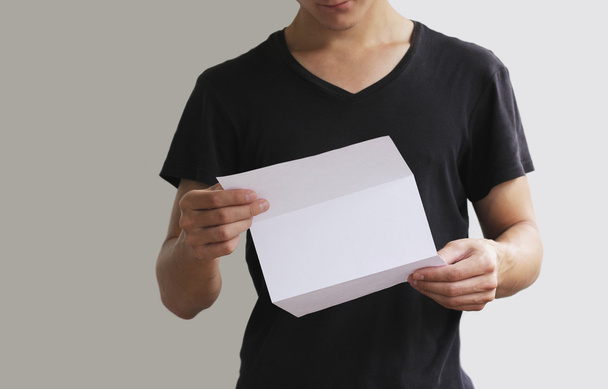 Man reading blank white flyer brochure booklet. Leaflet presentation. Pamphlet hold hands. Man show clear offset paper. Sheet template. - Foto, afbeelding