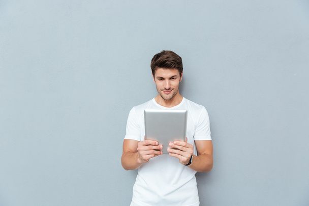 Happy casual man using tablet computer - Photo, Image
