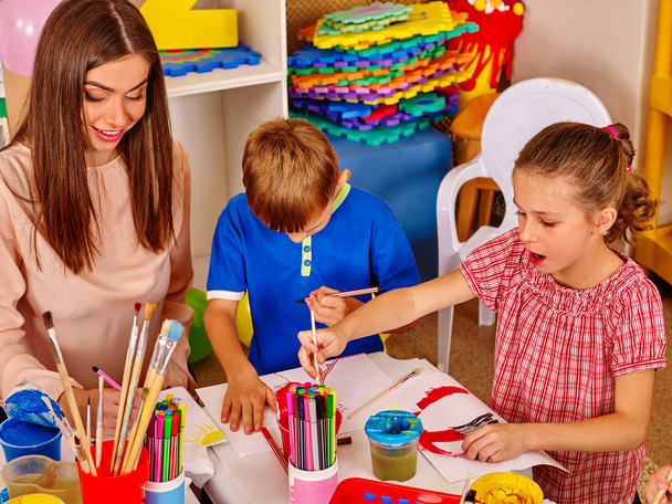 Crianças com professor mulher pintura no papel no jardim de infância
 . - Foto, Imagem
