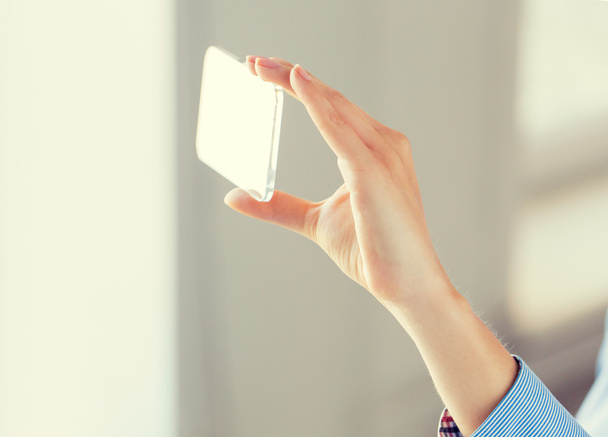 close up of woman with transparent smartphone - Foto, Imagen