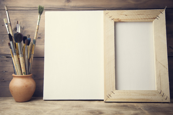 canvas, paintbrush on wooden background - Foto, imagen