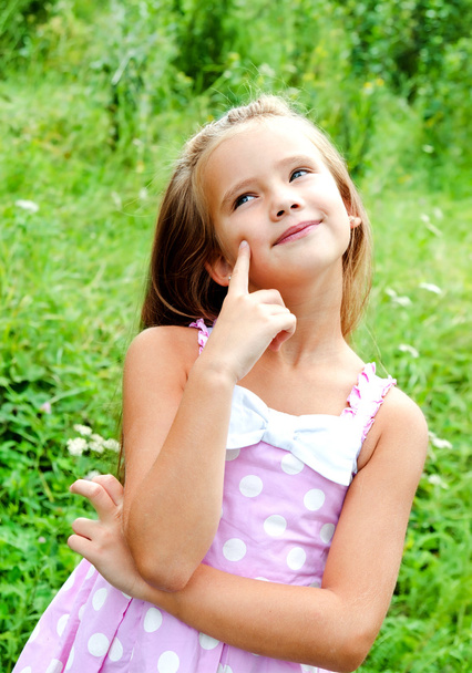 Portrait of adorable thinking little girl in summer day  - Valokuva, kuva