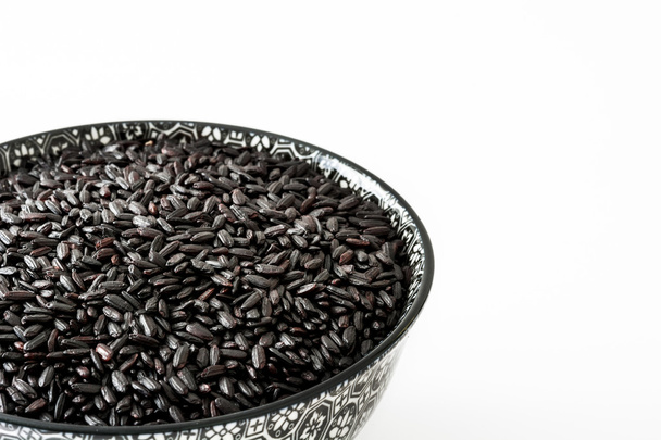roher schwarzer Reis in einer Schüssel isoliert auf weißem Hintergrund - Foto, Bild