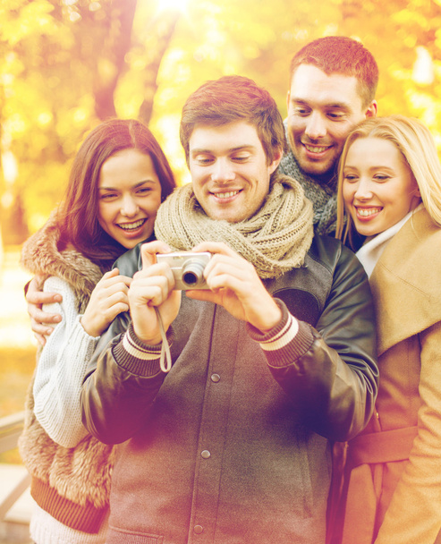 group of friends with photo camera in autumn park - Фото, зображення