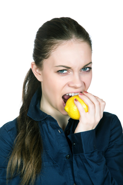 The girl with a sour mine on the person bites  lemon - Photo, Image