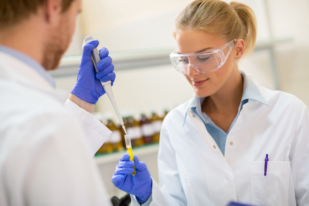 Θηλυκό χημικός χαμογελώντας ενώ κατέχουν δοκιμή πιπέτα - Φωτογραφία, εικόνα