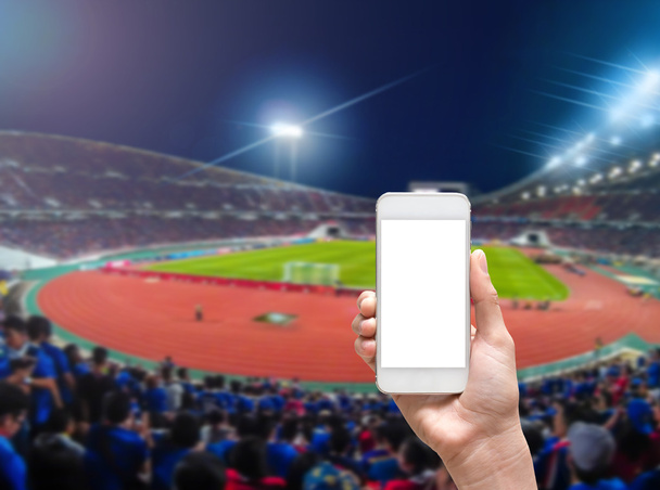 Tenuta a mano smart mobile allo stadio
  - Foto, immagini