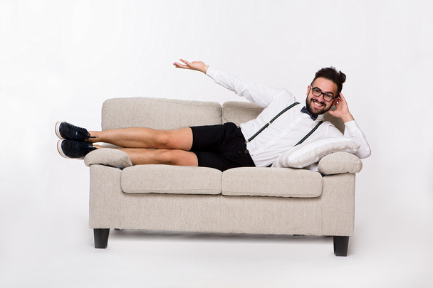 Smiling handsome man lying on couch - Foto, afbeelding