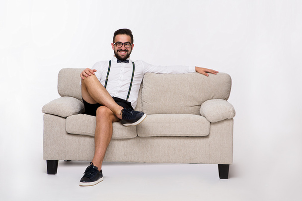 Smiling handsome man sitting on couch - Фото, изображение