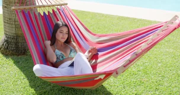 vrouw in bikini leesboek in hangmat - Video