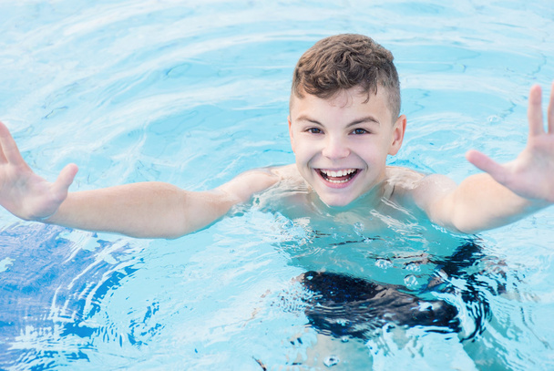 gelukkige jongen in zwembad - Foto, afbeelding