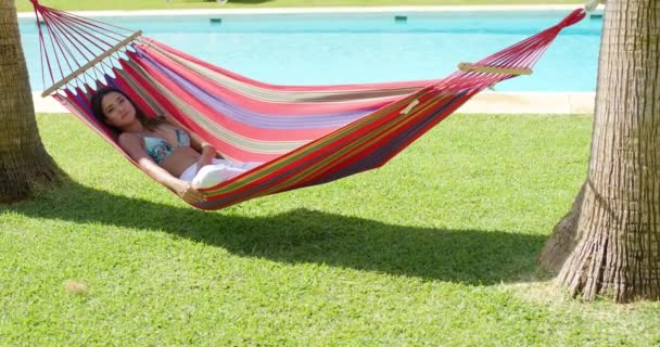 young woman in colorful hammock - Materiał filmowy, wideo