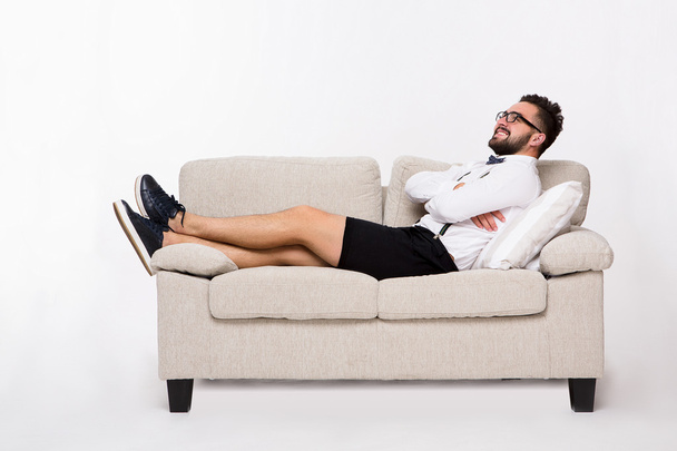 Smiling handsome man lying on couch - Фото, изображение