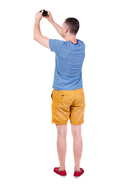 Vista posterior de hombre fotografiando. Turismo en shorts. - Foto, Imagen