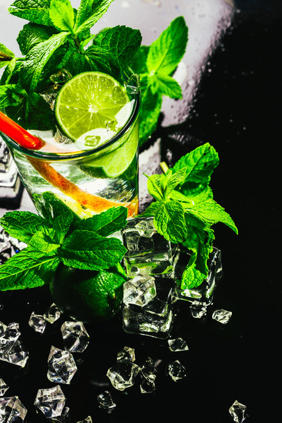glass of mojito with lime and mint ice cube close-up red straw - 写真・画像