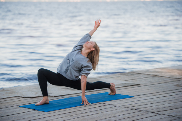 Jeune femme sportive pratiquant le yoga sur la plage
 - Photo, image